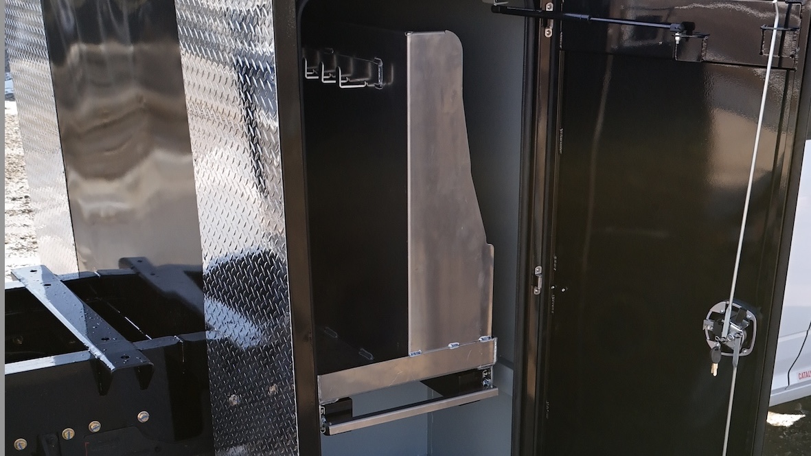 Transverse cabinet with extruded aluminum doors open on RAM 5500 truck deck fabricated by Core Fabrication for oilfield use