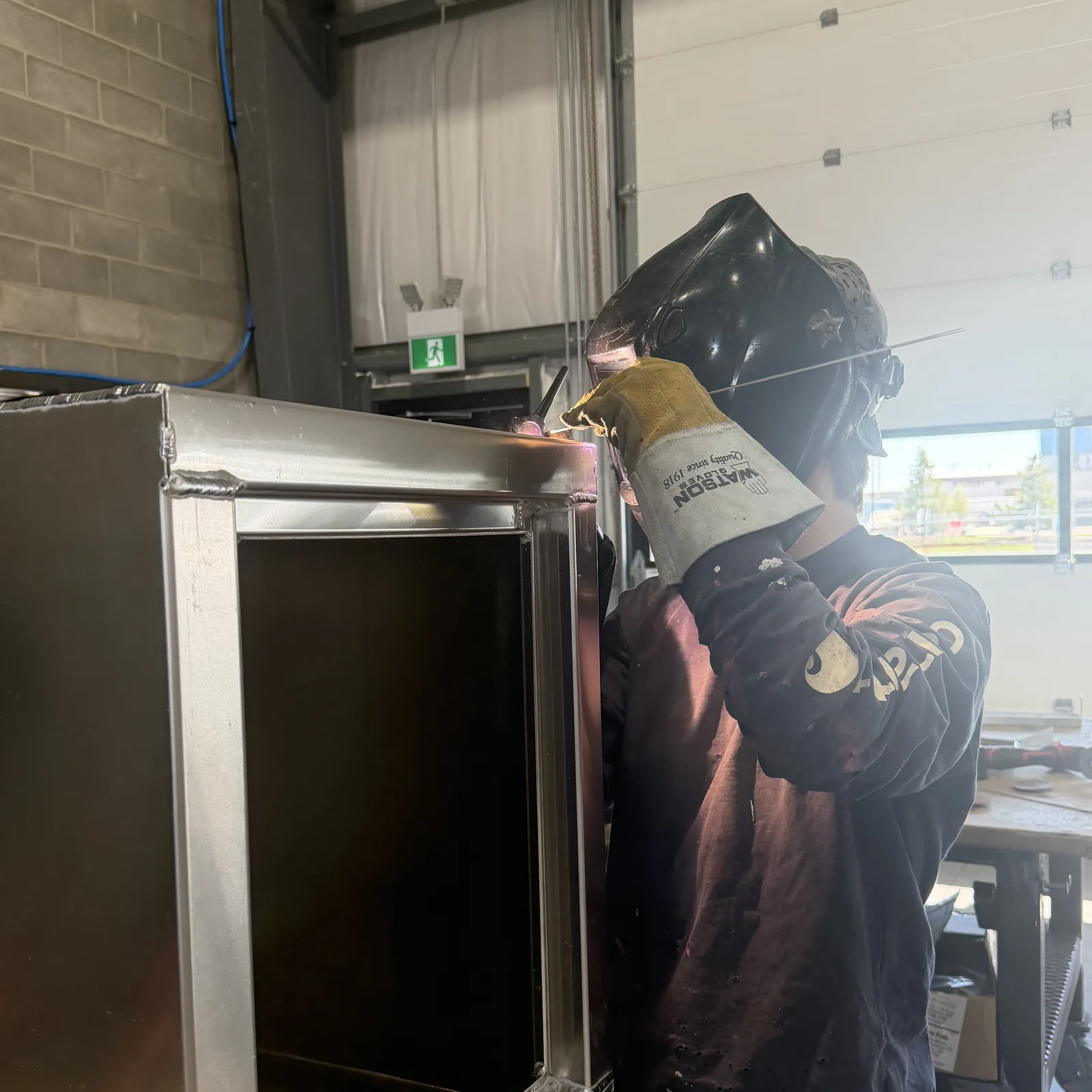 Welder fabricating an aluminum enclosure in the Core Fabrication shop